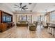 Spacious living room with wood-look tile floors, a ceiling fan, and comfortable seating at 12292 Lyon Pine Ln, Odessa, FL 33556