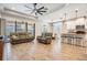 Spacious living room with wood-look tile floors, a ceiling fan, and comfortable seating at 12292 Lyon Pine Ln, Odessa, FL 33556