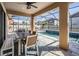 Covered patio with dining area overlooking the refreshing pool at 12292 Lyon Pine Ln, Odessa, FL 33556