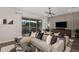 Stylish living room featuring a large sectional, patterned accent wall, and an adjacent outdoor dining area at 12682 Glenn Creek Dr, Riverview, FL 33569