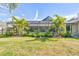 Backyard view of the house with a screened pool and lush landscaping at 14031 Shady Shores Dr, Tampa, FL 33613