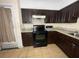 View of the kitchen's cooktop, microwave, and dark wood cabinets at 14810 N 30Th St, Lutz, FL 33559