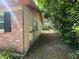 Brick home with overgrown vegetation along the side of the house at 14810 N 30Th St, Lutz, FL 33559