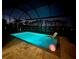 Luminous pool at night with surrounding lights at 14838 Paddock Pond Ave, Lithia, FL 33547