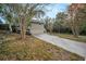 Home's exterior featuring a driveway and side view of the house with mature trees at 1512 Big Bass Dr, Tarpon Springs, FL 34689