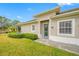 Rear view of home showcasing a blue door and lush landscaping at 16130 Craigend Pl, Odessa, FL 33556