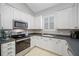 Modern white kitchen with stainless steel appliances and tiled floors at 16130 Craigend Pl, Odessa, FL 33556