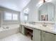 Bright bathroom featuring a soaking tub, dual sinks, and a vanity area at 1632 Gray Bark Dr, Oldsmar, FL 34677