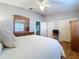 Bright bedroom featuring hardwood floors, a white comforter, and access to the hallway at 1632 Gray Bark Dr, Oldsmar, FL 34677