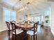 Dining area featuring a large wood table with seating, chandelier lighting and hardwood flooring at 1632 Gray Bark Dr, Oldsmar, FL 34677