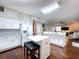 Open kitchen layout with white cabinets, an island, and a seamless transition to the living and dining spaces at 1632 Gray Bark Dr, Oldsmar, FL 34677