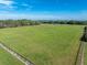 Aerial view of expansive pasture with horse, split rail fencing, and barn at 17120 Boy Scout Rd, Odessa, FL 33556