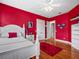 Red walls, white bed frame, and hardwood floors at 17120 Boy Scout Rd, Odessa, FL 33556