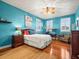 Bedroom with teal walls, hardwood floors, and ceiling fan at 17120 Boy Scout Rd, Odessa, FL 33556