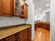 View into kitchen from wet bar, showcasing wood cabinets and granite countertops at 17120 Boy Scout Rd, Odessa, FL 33556