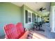 Inviting porch with red adirondack chairs and a striped rug at 17120 Boy Scout Rd, Odessa, FL 33556