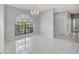 Bright dining room with a large arched window, tile flooring, and elegant chandelier at 1803 Tawnee Pl, Brandon, FL 33510