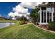 Home's backyard features a pond view, lush landscaping, and a screened patio at 1937 Sterling Glen Ct, Sun City Center, FL 33573