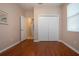 Hardwood floor bedroom with an open door to hallway and double door closet at 1937 Sterling Glen Ct, Sun City Center, FL 33573