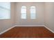 Well-lit bedroom with hardwood floors and two arched windows at 1937 Sterling Glen Ct, Sun City Center, FL 33573