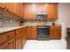 Modern kitchen features granite countertops, stainless steel appliances, and wood cabinets at 1937 Sterling Glen Ct, Sun City Center, FL 33573