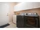 Laundry room with washer, dryer, cabinets, and utility sink at 1937 Sterling Glen Ct, Sun City Center, FL 33573