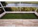 Screened patio with artificial turf and pond view at 1937 Sterling Glen Ct, Sun City Center, FL 33573