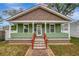 Charming green bungalow with a welcoming front porch and brick pathway at 2715 14Th N Ave, St Petersburg, FL 33713