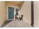 Inviting front entry with teal door and cozy seating at 29913 Southwell Ln, Wesley Chapel, FL 33543