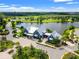 Aerial view of community clubhouse near lake with lush landscaping at 3421 Janna Grace Way, Land O Lakes, FL 34638