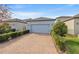 House exterior with a gray garage door and brick driveway at 3421 Janna Grace Way, Land O Lakes, FL 34638