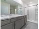 Bathroom with double vanity, large mirror, and shower at 34219 Sorrel Mint Dr, Wesley Chapel, FL 33543