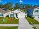 New home exterior with a two-car garage and well-manicured lawn at 34219 Sorrel Mint Dr, Wesley Chapel, FL 33543