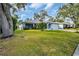 Single-story home with light blue exterior, attached garage, and lush green lawn at 3584 Oak Lake Dr, Palm Harbor, FL 34684