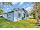 Light blue house with a large screened porch and lush green lawn at 3584 Oak Lake Dr, Palm Harbor, FL 34684