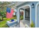 Inviting front porch with arched entryway, screen door, and charming landscaping at 3584 Oak Lake Dr, Palm Harbor, FL 34684