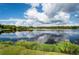 Scenic lake view with lush greenery and a partly cloudy sky at 36750 Us Highway 19 N # 04221, Palm Harbor, FL 34684