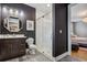 Modern bathroom with a walk-in shower, dark vanity, and octagon mirror at 4224 W Kensington Ave, Tampa, FL 33629