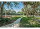 Tennis court with surrounding trees and pathway at 4333 Trails Dr # 10-1, Sarasota, FL 34232