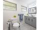 Modern bathroom with gray cabinets, white countertop, and marble flooring at 4702 W Bay Ave, Tampa, FL 33616