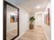 Bright hallway with large mirror, artwork, and light wood flooring at 4702 W Bay Ave, Tampa, FL 33616