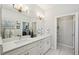 Modern bathroom with double vanity and a view of the bedroom at 4722 Legacy Park Dr, Tampa, FL 33611