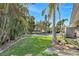 Beautiful backyard featuring lush landscaping, grass, and an in-ground pool under a clear blue sky at 4801 Venetian Ne Pl, St Petersburg, FL 33703