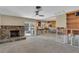 Open-concept living room with stone fireplace, ceiling fan, tile floor, and access to the kitchen at 4801 Venetian Ne Pl, St Petersburg, FL 33703