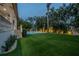 Landscaped backyard with a pool, lighting and artificial turf at 5020 W Dickens Ave, Tampa, FL 33629