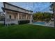 Backyard view of home with pool, lush landscaping, and lighting at 5020 W Dickens Ave, Tampa, FL 33629