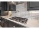 Modern kitchen features gas cooktop, white subway tile, and dark cabinetry at 5020 W Dickens Ave, Tampa, FL 33629