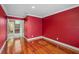 Simple bedroom with red walls and hardwood floors at 513 Suwanee Cir, Tampa, FL 33606