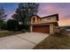 Two-story house with brown garage door and landscaped yard at dusk at 513 Suwanee Cir, Tampa, FL 33606