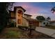 Two-story house with brown garage door, fountain, and landscaped yard at dusk at 513 Suwanee Cir, Tampa, FL 33606